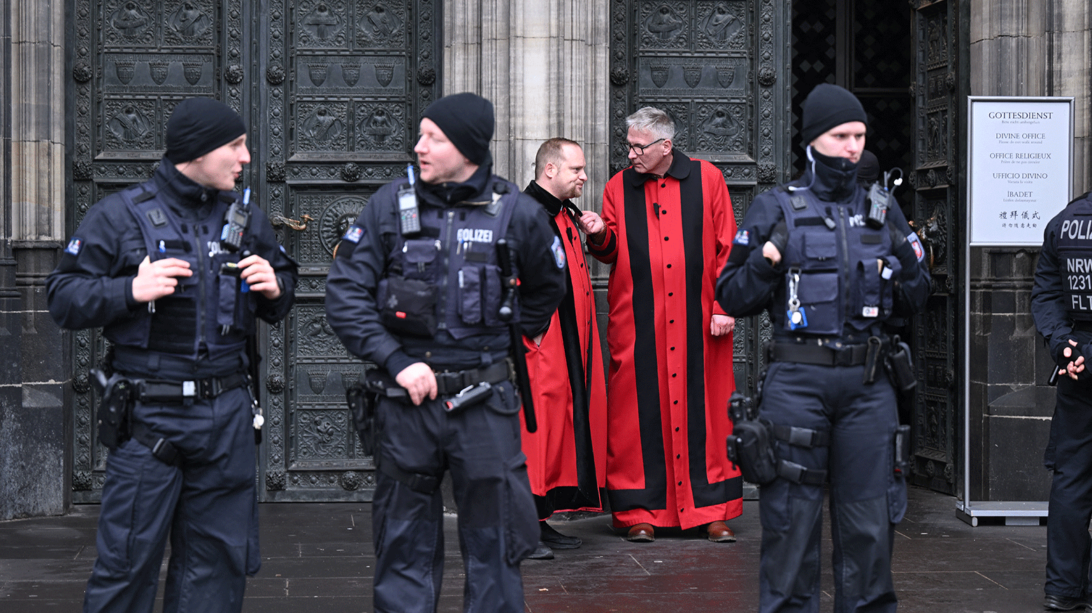 Sidesmen of the Cathedral talk as policemen stand in front of the Cologne Cathedral on December 24, 2023. (Photo: AFP)