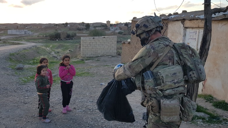 Coalition soldier give gifts to children in Hemze Beg village, northeast Syria, February 17, 2021 (Wladimir van Wilgenburg/Kurdistan 24).