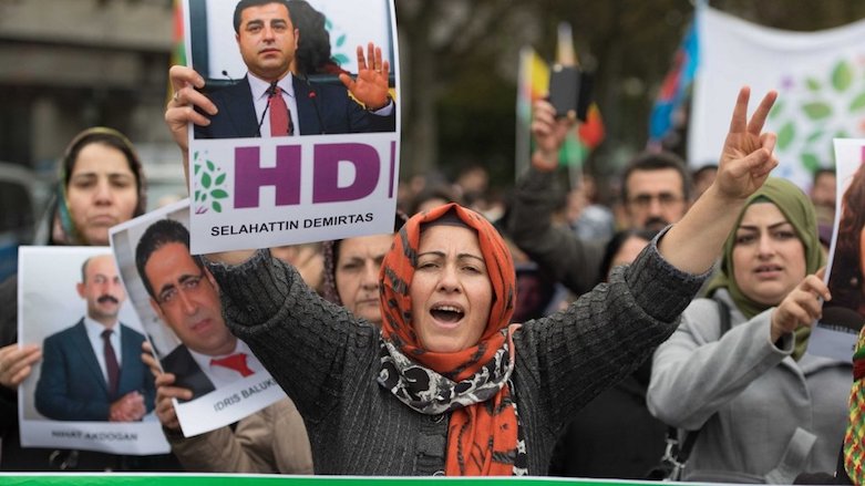 A woman holds up a photo of Kurdish leader Selahattin Demirtas in a demonstration to protest against the Turkish government's policy on November 4, 2016, in Frankfurt, Germany (Photo: Boris Roessler, DPA/AFP)