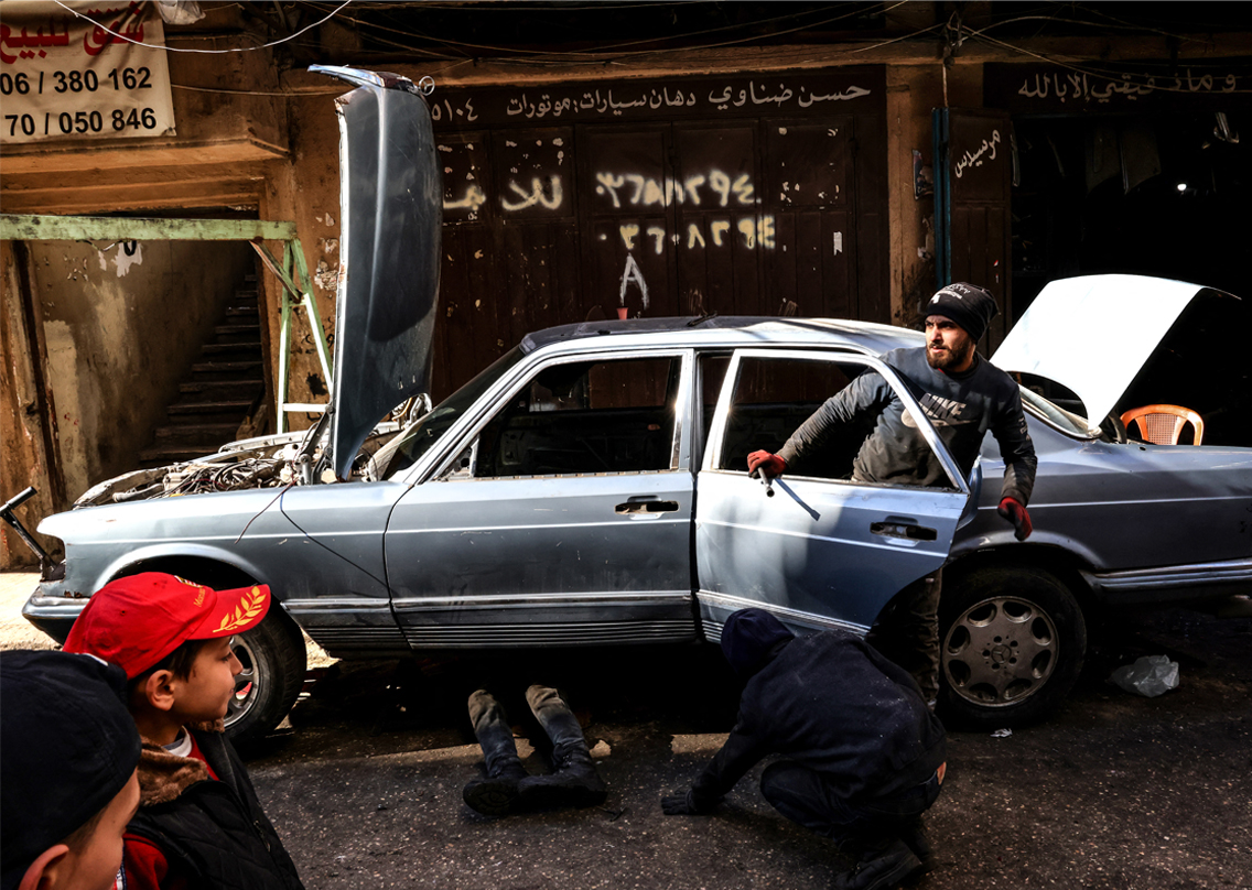 Mechanics repair a car in an alley of the northern Lebanese city of Tripoli's empoverished neighbourhood of Bab al-Tabbane, Jan. 17, 2022. (Photo: Joseph Eid/AFP)