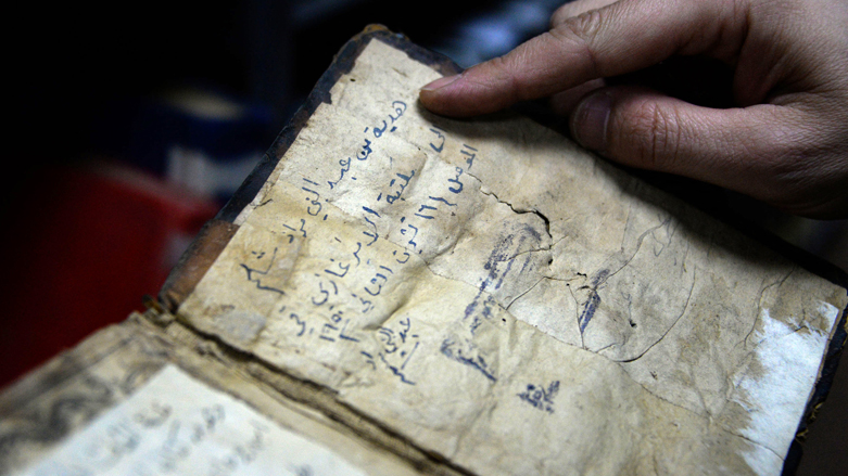 A librarian shows a book from the library collection of the University of Iraq's northern city of Mosul, on Jan. 31, 2022. (Photo: Zaid al-Obeidi/AFP)