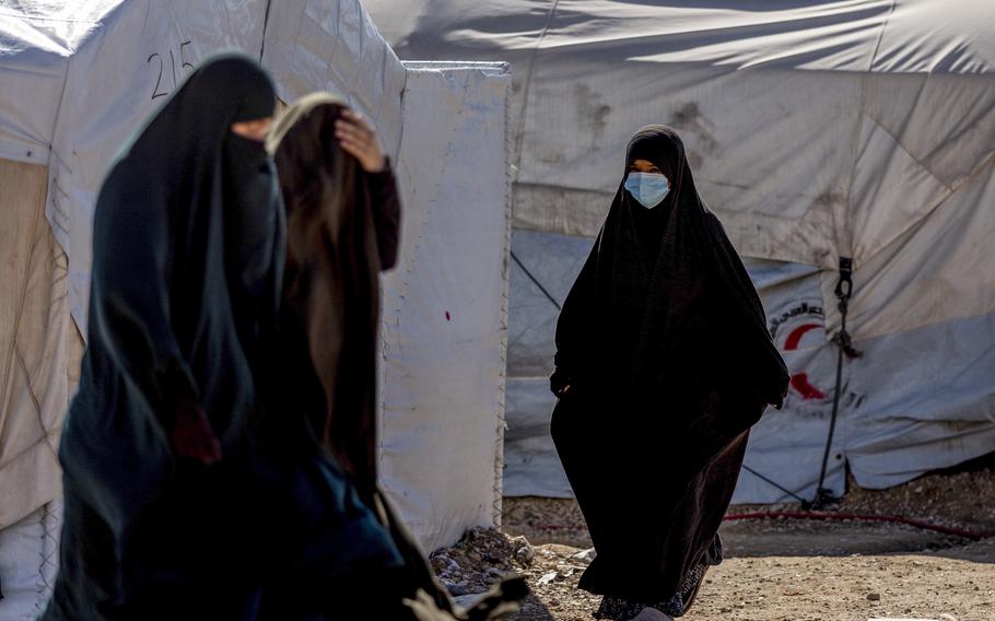 Women walk in the Roj detention camp in northeast Syria, Wednesday, Feb. 9, 2022. Syrian Kurdish authorities are struggling to supervise tens of thousands of ISIS-affiliated foreign nationals who they are holding in camps and prisons across