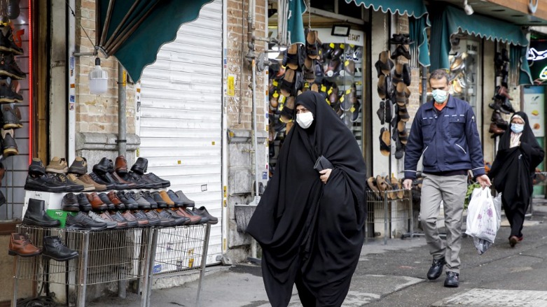 A woman walks past a shoe-seller's shop in the south of the capital city of Tehran, February 20, 2022. (Photo: AFP)