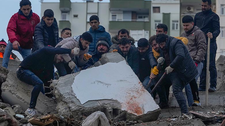 Men search for people among the debris in a destroyed building in Adana, Turkey, Monday, Feb. 6, 2023 (Photo: Khalil Hamra/ AP)