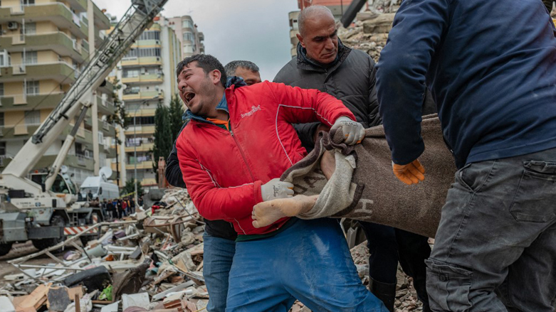 A rescuer reacts as he carries a body found in the rubble in Adana, Feb. 6, 2023. (Photo: Can Erok/AFP)