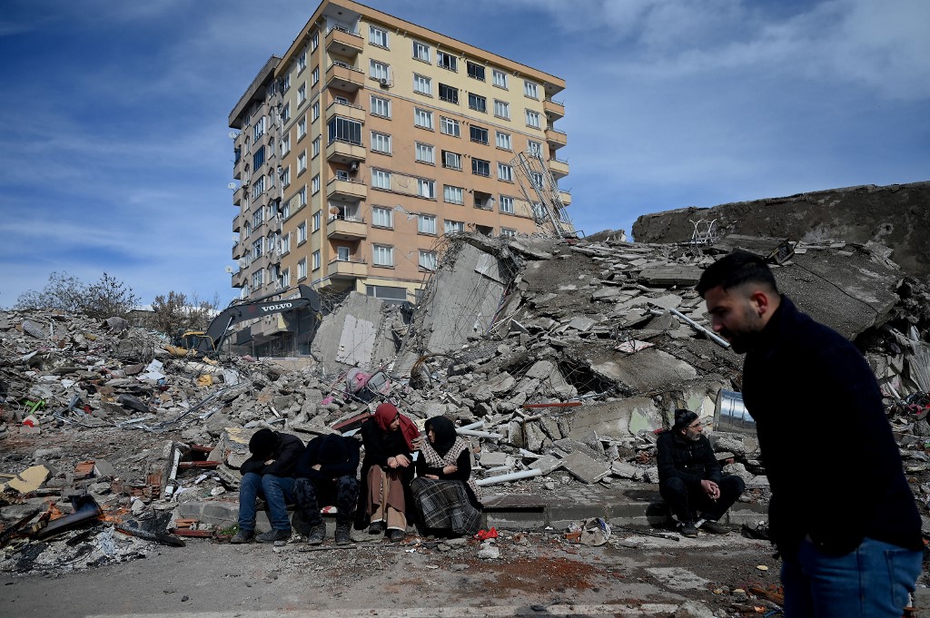 Families wait through the rubble of buildings in kahramanmaras, the quake's epicentre, after a 7.8-magnitude earthquake struck the country's southeast, Feb. 7, 2023. (Photo: Ozan Kose/AFP)