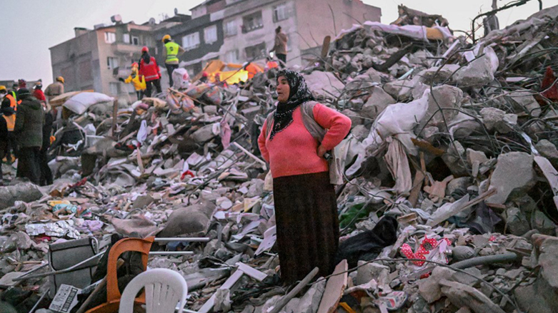 A woman stands in the rubble hoping her relatives to be found by rescuers in Hatay, as rescue teams began to wind down the search for survivors, Feb. 13, 2023. (Photo: Bulent Kilic/AFP)