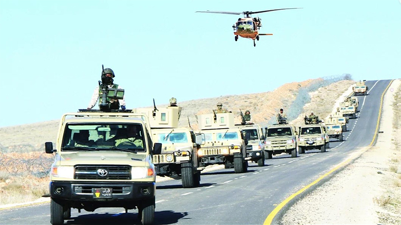 عربات عسكرية ترافقها حوامة على طريقٍ صحراوي- وكالات