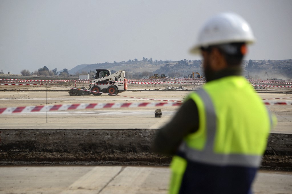 A worker in green vest is pictured on the under-the-construction runway of Mosul International Airport, Feb. 25, 2023. (Photo: Zaid Al-Obeidi/AFP)