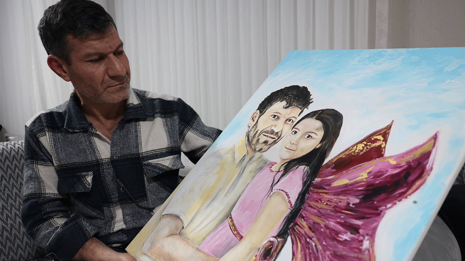 Mesut Hancer holds a painting of his daughter 15-year-old-daughter Irmak, victim of the earthquake that hit Turkey's southeast on February 6, 2023, during an interview, in Ankara on January 11, 2024. (Photo: AFP)