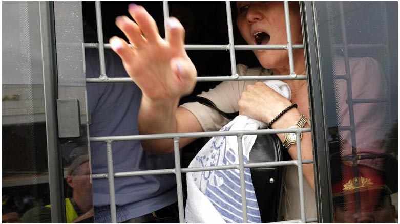 Kazakistan'ın Almatı kentindeki protestolarda gözaltına alınan bir zanlı (AP)