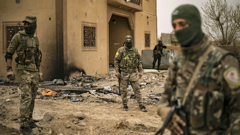 SDF members walk in the village of Baghouz on March 24, 2019, a day after the Islamic State group’s “caliphate” was declared defeated. (Delil Souleiman/AFP via Getty Images)