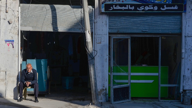 An Iraqi laundry shop owner sits outside his shop in the northern city of Mosul amid general restrictions on movement due to the COVID-19 pandemic, on January 10, 2021. (Photo: AFP / Zaid AL-OBEIDI)