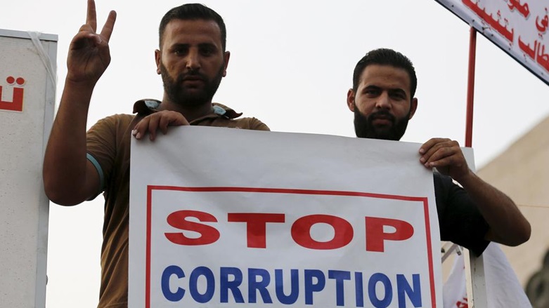 Iraqi protesters hold a sign calling to end institutional corruption. (Photo: Archive)