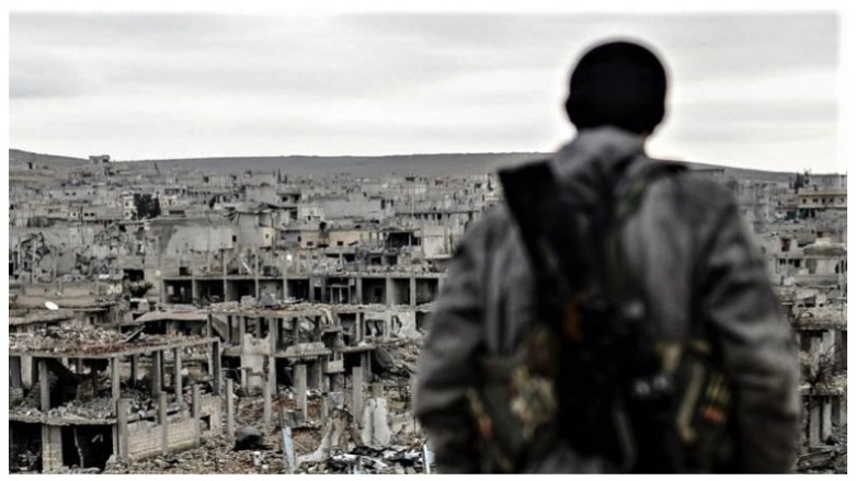 A Kurdish marksman stands on top of a building in the Syrian town of Kobani, Jan. 2015. (Photo: AFP/Bulent Kilic)