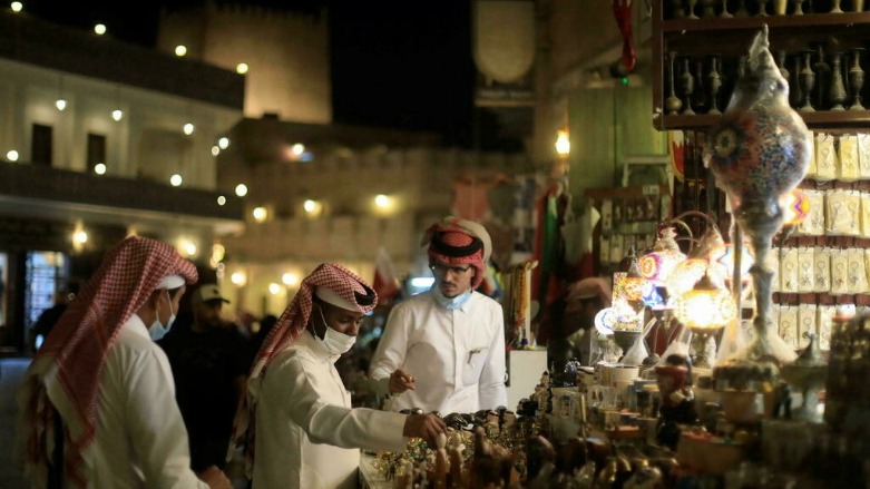 أشخاص يرتدون الكمامات الواقية أثناء التبضع في أحد الأسواق القطرية. © رويترز