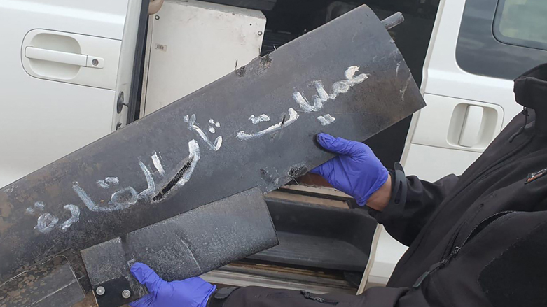 A military expert holding a part of one of two armed drones the US-led coalition against the Islamic State (IS) group in Iraq said it shot down while targeting a compound hosting coalition, Jan. 3, 2022. (Photo: AFP Photo/Handout/Coalition)
