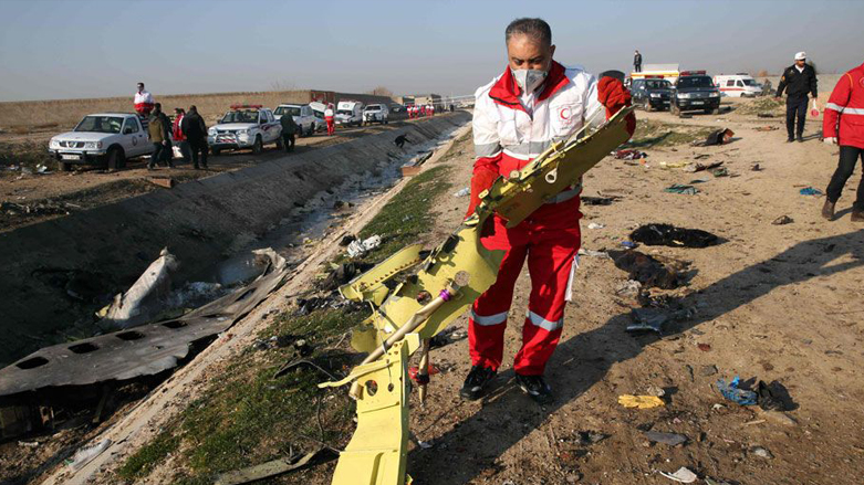 A rescue worker picks up the remains of the crashed plane. (Photo: AFP)