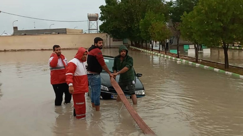 A handout picture made available by the Iranian Red Crescent on January 4, 2022 shows members assisting to tow a vehicle stuck in floods in Hormozgan Province in the south of Iran. (Photo: Iranian Red Crescent / AFP)