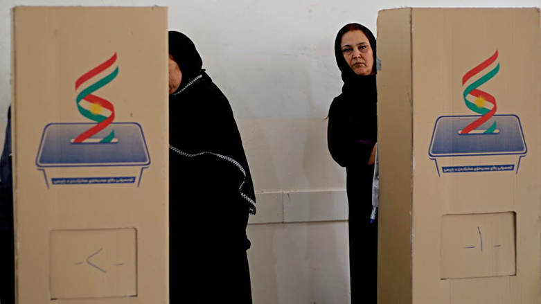 Two women behind booths at one of the voting centers during 2018 Kurdistan Parliament elections. (Photo: AP)