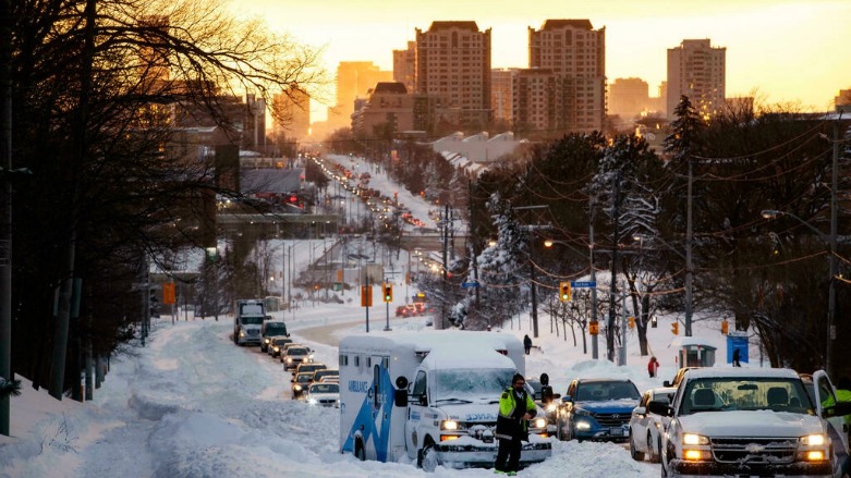 مُسعف ينتظر وصول قاطرة لسحب سيّارة إسعاف علقت في الثلج في تورونتو في مقاطعة أونتاريو في 17 كانون الثاني/يناير 2022 - الصورة لفرانس 24