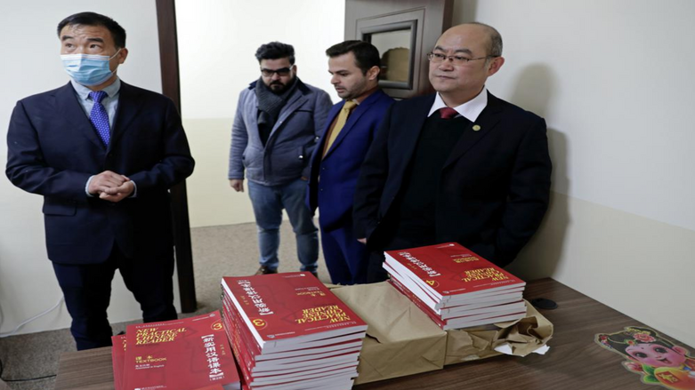 Chinese lecturer, Zhiwei Hu, left, teachers and officials of the Chinese Language Department stand in front of Chinese language books intended for students in Salahaddin University in Irbil, Wednesday, Jan. 19, 2021. (Photo: AP/Khalid Moham