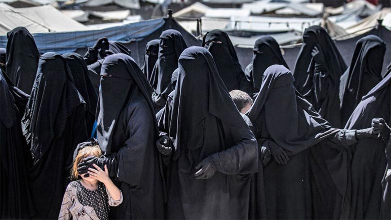 Women and a child queue to receive humanitarian aid packages at the Kurdish-run al-Hol camp (Photo: Delil Souleiman/ AFP)