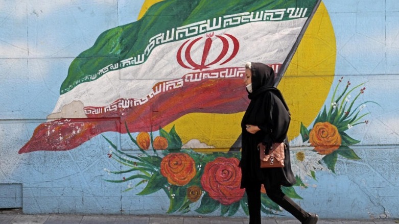 في هذه الصورة التي التُقطت في 11 تشرين الأول/أكتوبر 2022، امرأة تسير أمام لوحة جدارية في العاصمة الإيرانية طهران © اتا كيناري / ا ف ب/ارشيف