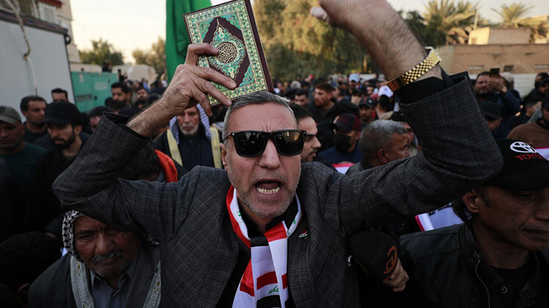 متظاهر يحمل القرآن الكريم في بغداد