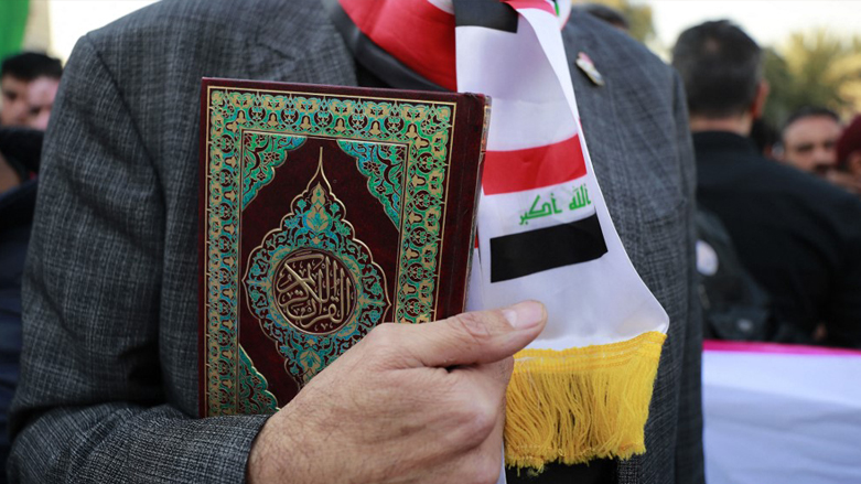 An Iraqi man holds the Koran during a demonstration outside the Swedish embassy in Baghdad on Jan. 23, 2023. (Photo: Ahmad Al-Rubaye/AFP)