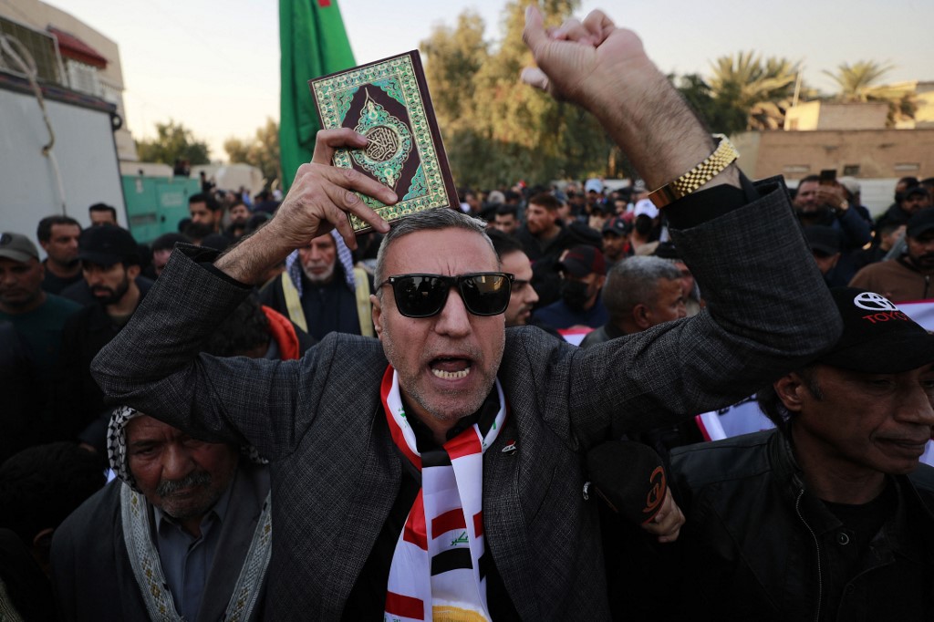 An Iraqi man holds the Koran and shout slogans during a demonstration outside the Swedish embassy in Baghdad on Jan. 23, 2023. (Photo: Ahmad Al-Rubaye/AFP)