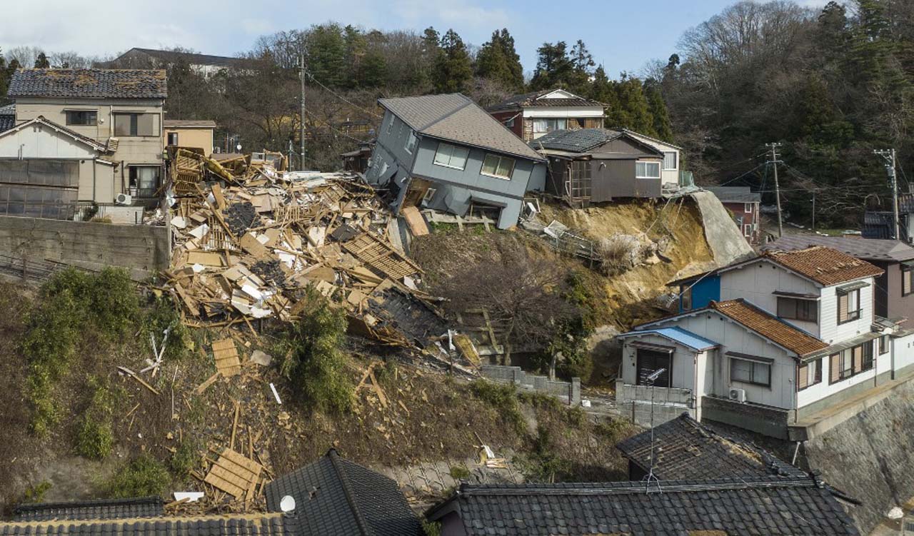 Damaged houses, including one totally collapsed (C), are pictured along a street in Wajima, Ishikawa prefecture, Jan. 2, 2024. (Photo: Fred Mery/AFP)