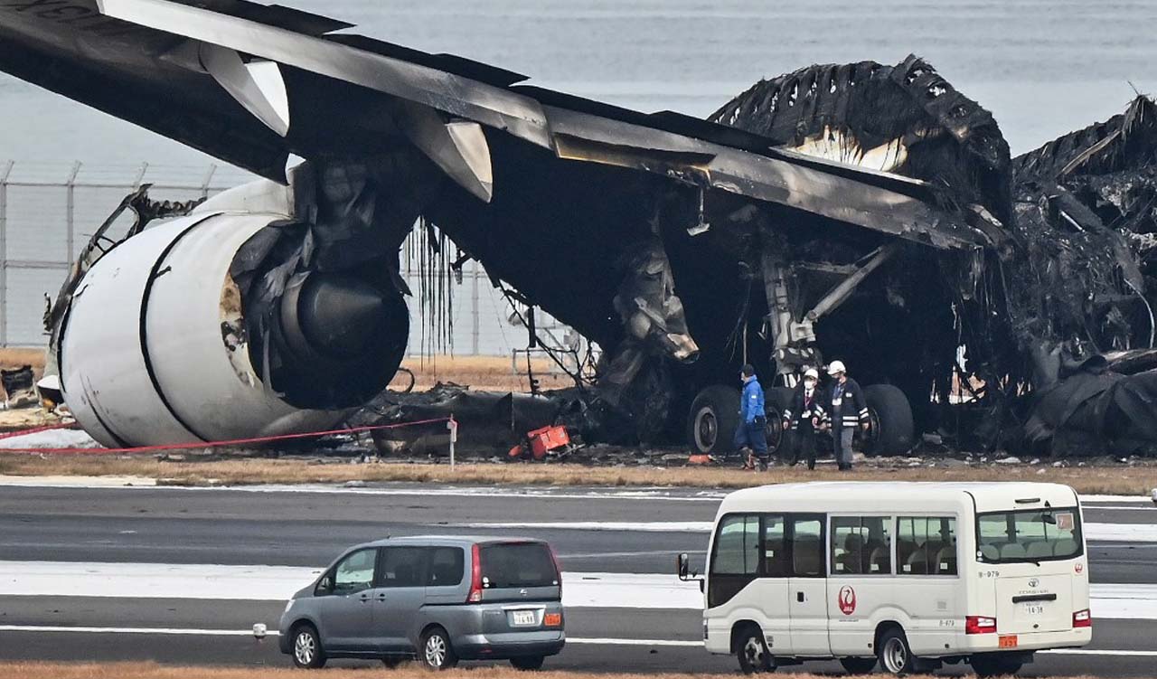 Officials look at the burnt wreckage of a Japan Airlines (JAL) passenger plane on the tarmac at Tokyo International Airport at Haneda in Tokyo, Jan. 3, 2024. (Photo: Richard A. Brooks/AFP)