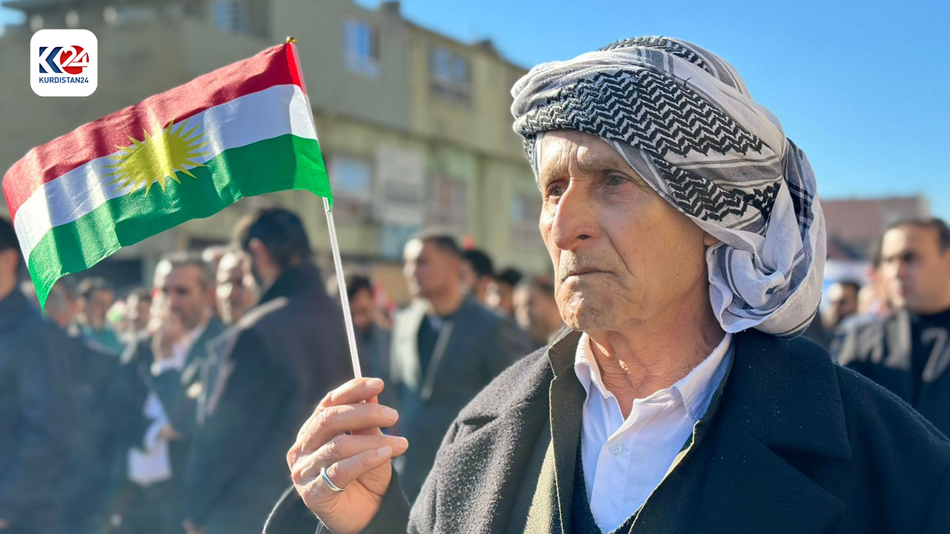 An elderly holds a Kurdistan Region flag in Duhok during a protest against IRGC attacks on Erbil, Jan. 18, 2024. (Photo: Kurdistan24)
