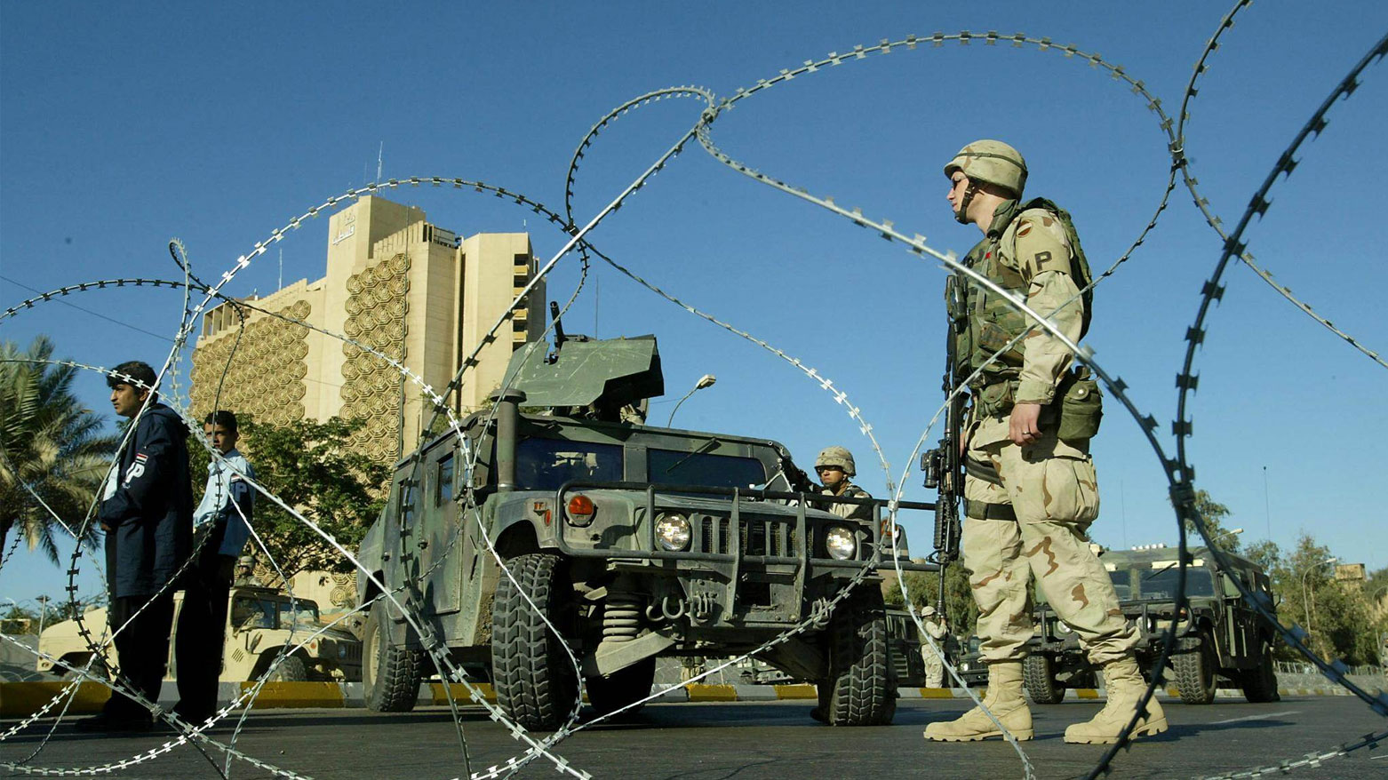 جنود أميركيون وأفراد من الشرطة العراقية بجانب السفارة الأميركية ببغداد (فرانس برس)