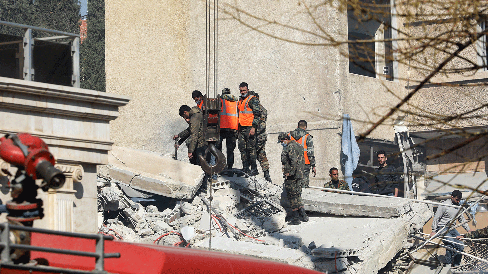 Security and emergency personnel search the rubble of a building destroyed in a reported Israeli strike in Damascus on January 20, 2024. (Photo: AFP)
