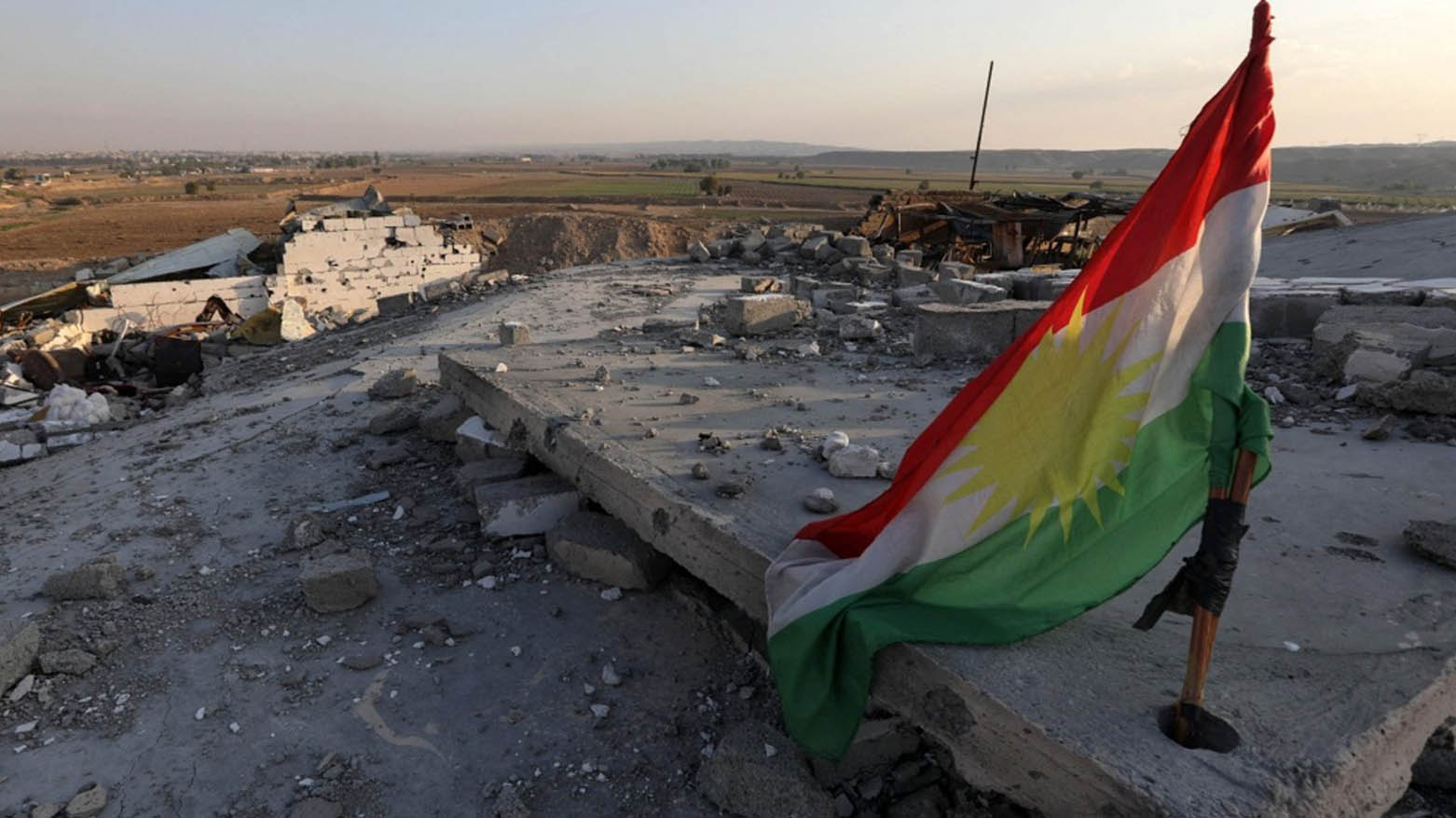 A Kurdish flag is pictured amid the destruction caused by a reported Iranian rocket attack near town city of Altun Kupri (Pirde), north of Kirkuk, in Iraq's autonomous Kurdistan Region, Nov. 23, 2022. (Photo: AFP)