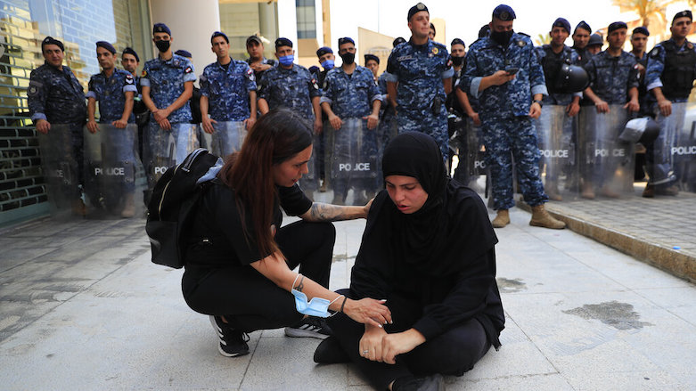 A woman from the Families of the victims of the 2020 explosion at Beirut’s seaport, left, comforts a woman who fall down while she was pushed back by Lebanese army soldiers, in Beirut, Lebanon, July 9, 2021. (Photo: Hussein Malla/AP)