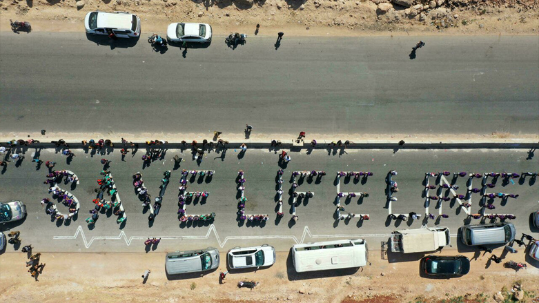 Aid workers formed a human chain to advocate for keeping open a border crossing through which aid is delivered to northeast Syria. (Photo: Omar Haj Khadour/AFP)