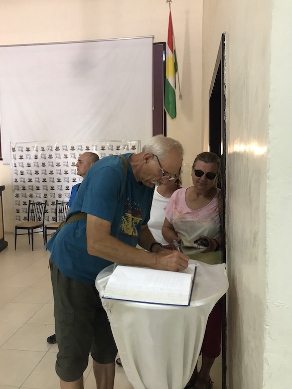Andrzej Walczak, who drove with a group tourists from Poland to the Kurdistan Region, signs a guest book at Duhok University on July 8, 2021. (Photo: Kurmanj Nheli)