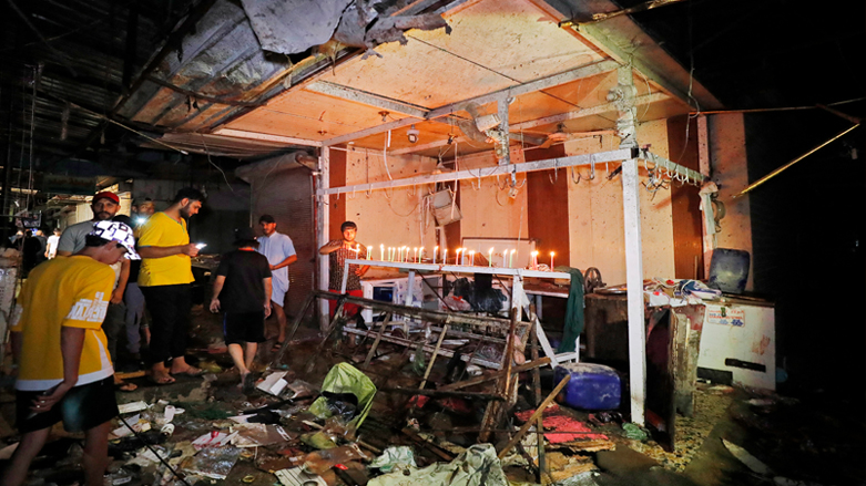 Iraqis light candles at the site of the explosion in a popular market in the Sadr City neighborhood, east of Baghdad, July 19, 2021. (Ahmad al-Rubaye/AFP)