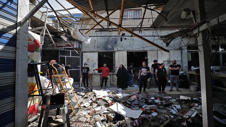 Iraqis inspect the site of the explosion a day earlier in a popular market in the Shiite-majority Sadr City neighborhood, east of the capital Baghdad on July 20, 2021. (Photo: AHMAD AL-RUBAYE/AFP)