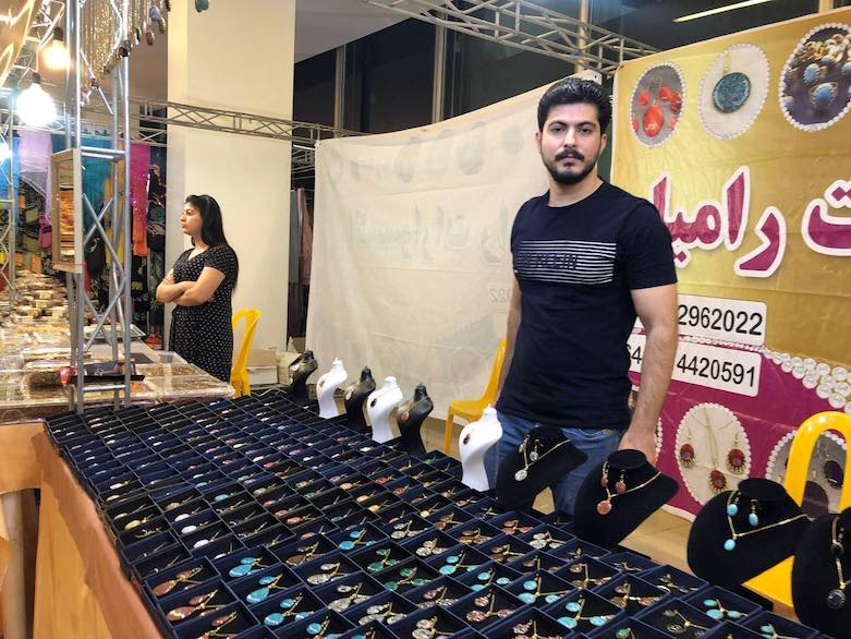 Ramyar Muhammed Taher, from Sina (Sanandaj), sells necklaces at the Iranian Kurdistan fair in Duhok, July 19, 2021. (Photo: Kurmanj Nhili)