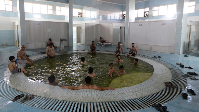 Men gather at the Hamam al-Alil baths, south of the northern Iraqi city of Mosul,  June 30, 2022. (Photo: Zaid Al-Obedi/AFP)