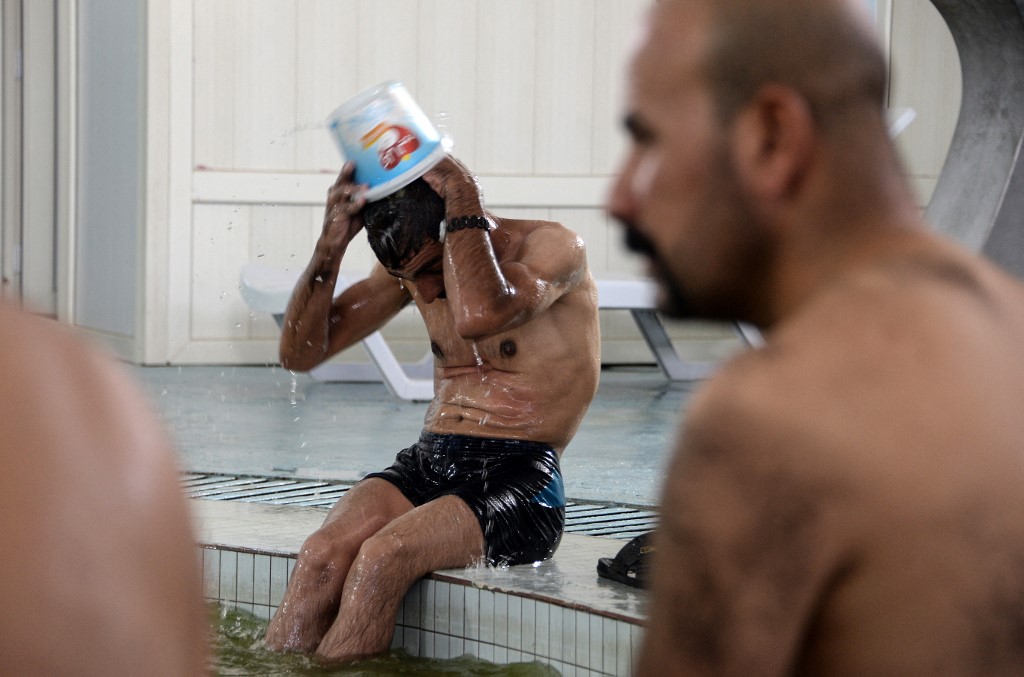 Men bathe at Hamam al-Alil baths, south of the northern Iraqi city of Mosul, June 30, 2022. (Photo: Zaid Al-Obeidi/AFP)