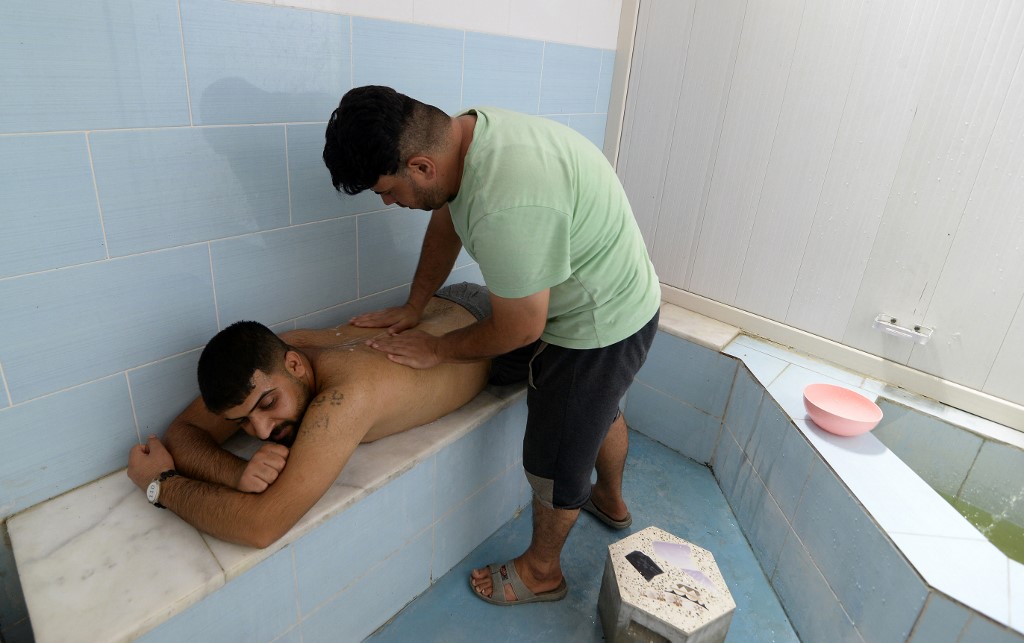 A client gets a massage at the Hamam al-Alil baths, south of the northern Iraqi city of Mosul, June 30, 2022. (Photo: Zaid Al-Obeidi/AFP)