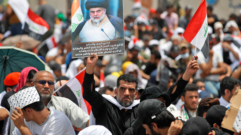 A supporter of Iraqi Shiite cleric Muqtada al-Sadr lifts a placard depicting him during a collective Friday prayer in Sadr City, east of Baghdad, July 15, 2022. (Photo: AFP)