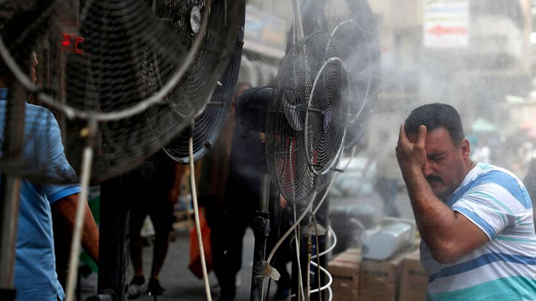 An Iraqi man cools himself down in front of water vaper-spraying fans provided on a street in Baghdad amid a heat spell, June 30, 2021 (Photo: Ahmad Al-Rubaye/AFP)