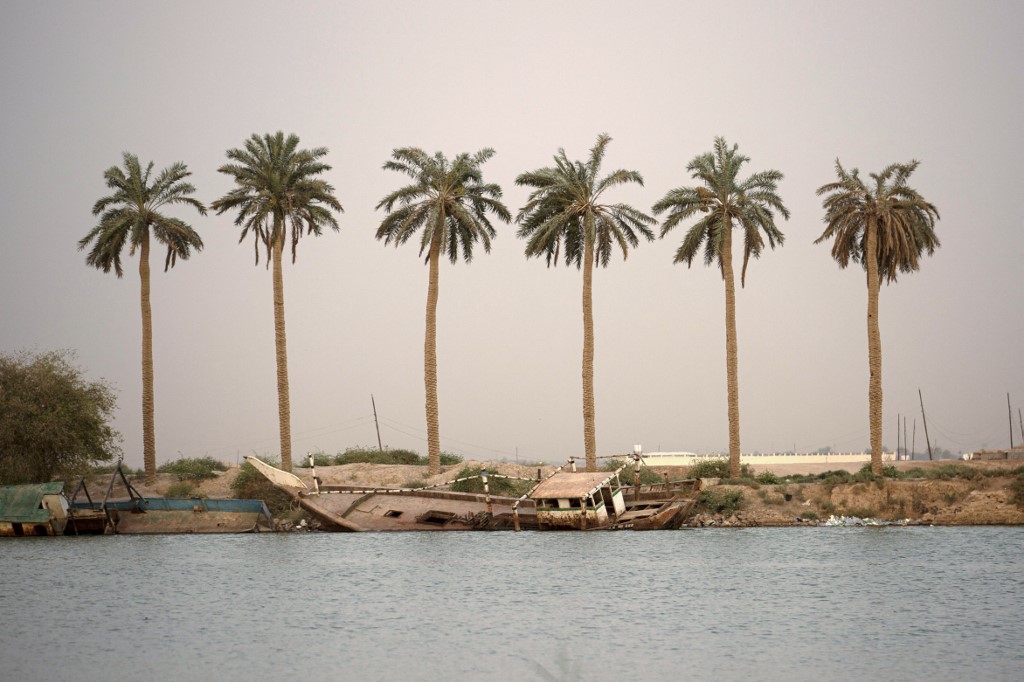 Palm trees stand at sunset near the Shatt al-Arab waterway in the southern Iraqi city of Basra, July 6, 2022. (Photo: Hussein Faleh/AFP)