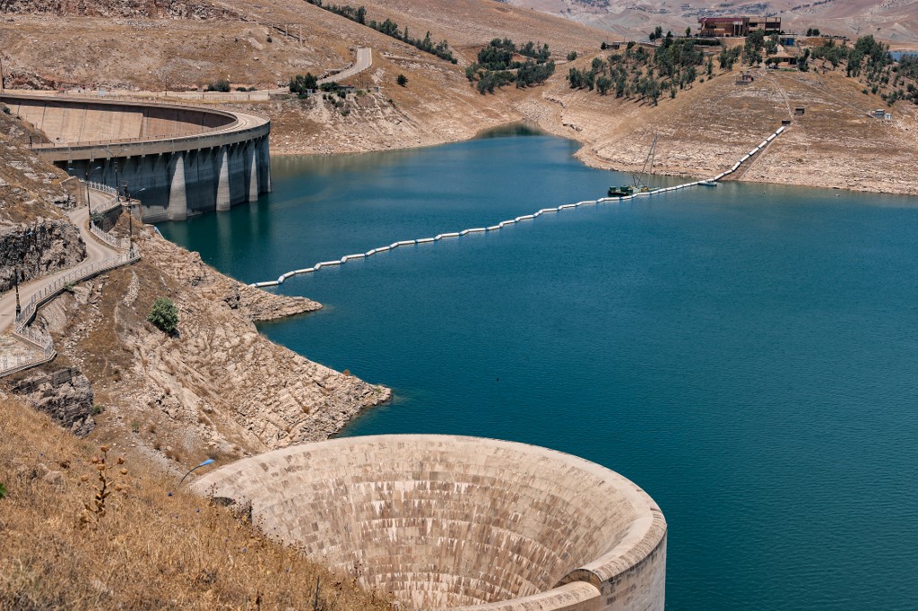 a view of the Dukan Dam (L behind), its emergency bell-mouth spillway (front), and the reservoir behind, in the Kurdistan Region's Sulaimani province, July 2, 2022. (Photo: Ahmad Al-Rubaye/AFP)